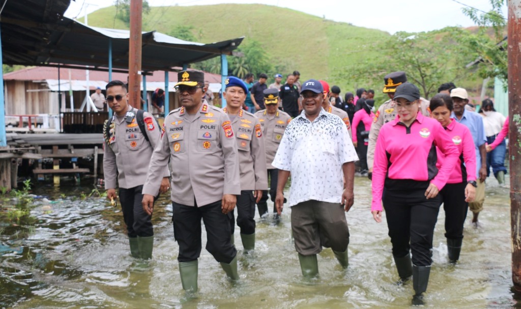 Kapolda Papua, Irjen Pol. Petrus Patrige R. Renwarin, S.H., M.Si., bersama Ketua Bhayangkari Daerah Papua Ny. Nova Patrige Renwarin dan Pejabat Utama (PJU) Polda Papua dan aparat kampung saat melewati jalan salah satu kampung yang terdampak luapan air danau sentani, Selasa (31/03/2026)