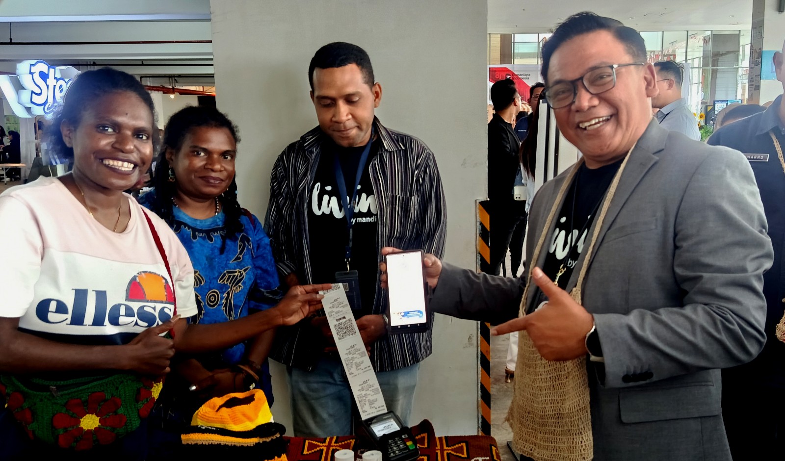 Regional CEO Bank Mandiri Region XII, Antonius Budi Setiawan saat bertransaksi membeli noken di salah satu stand UMKM milik mama-mama Papua